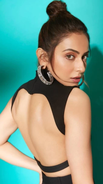 Rakul Preet Singh flaunts her toned back in the black backless top while wearing a silver hoop