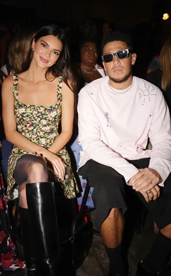 The Kardashians star sported a fun, floral dress and boots while attending the Marni Spring 2023 with her BF Devin Booker