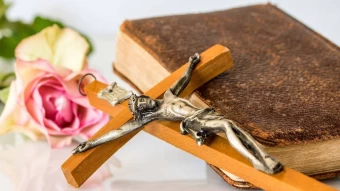 Beautiful Image Of A Mini Wooden Cross Placed Beside The Leather Bible And Pinkish Rose On Blurry White Backdrop In Commemoration Of The Good Friday