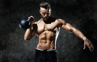 Muscular Man Carrying A Kettlebell To Work Out His Muscles