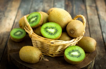 Pleasant Photo A Fruit Basket Of Whole And Halved Kiwis Displayed From A Tree Trunk Board