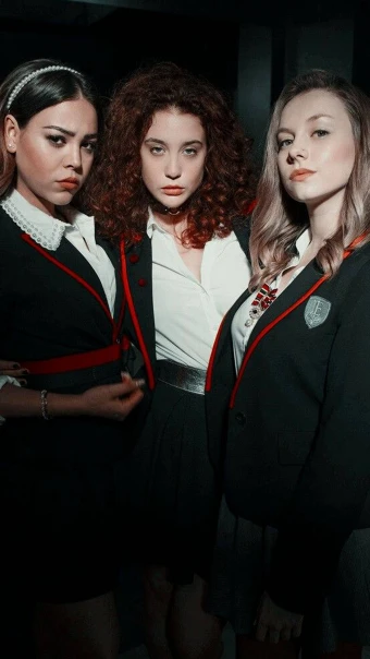 striking picture of three school girls wearing red and black uniform from the hit Netflix series entitled Elite