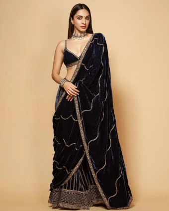 Kiara Advani looks absolutely spectacular in the deep blue velvet lehenga choli. Her choice of jewellery is a pretty choker and a bracelet. As always, she keeps her makeup minimal and hair styled with a centre parting
