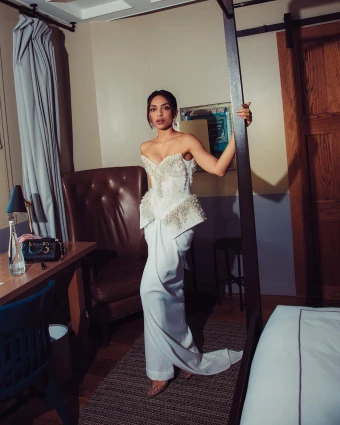 Sobhita Dhulipala wore a pristine white ensemble for the screening of her Hollywood Debut and dazzled fans with her sophisticated sartorial pick. features a bustier blouse and an elegant skirt that actually is trousers. The ensemble is from the designer's Aarohanam collection which he showcased during the Paris Couture Week Spring Summer 2024. The bustier top features an off-the-shoulder neckline, crystal embellishments, pearl and spiky adornments, peplum panels on the side to accentuate the hip