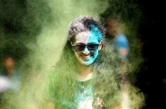 A youngster covered in coloured powder during Holi celebrations, in Mumbai