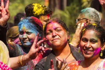 Women pose for pictures while celebrating Holi, in Ghaziabad