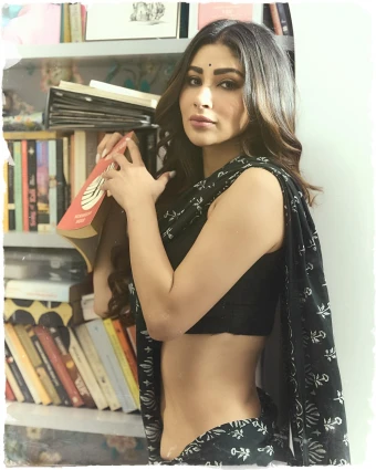 Mouni Roy exudes an old-world charm as she poses against a book cupboard, while holding a book in her hand.