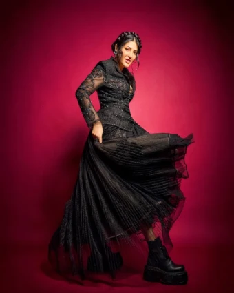 The dress includes dramatic, voluminous sleeves and a full skirt, adding a touch of Gothic glamour to her look.