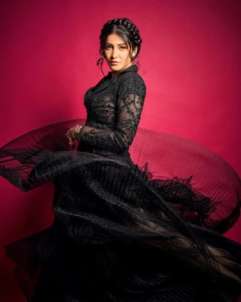 The gown features intricate lace and pleated details, creating an elegant and sophisticated silhouette that highlights Shruti's poise and grace