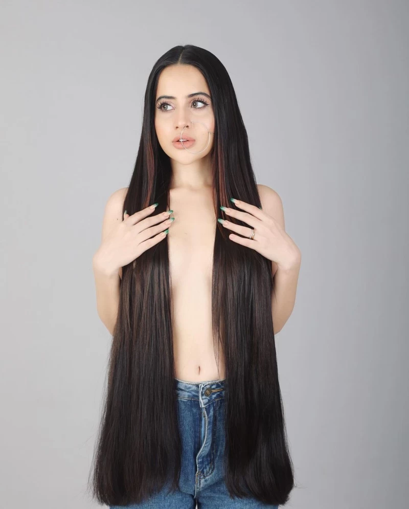 Urfi Javed can be seen posing topless as she covers her breasts with fake hair extensions