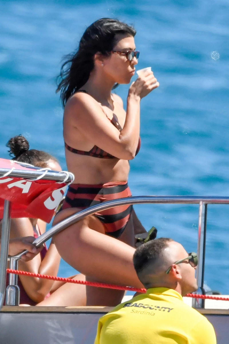 Kourtney Kardashian cooled off with a drink during a yacht excursion in Sardinia. She wore a high-waisted bikini and sunglasses as she soaked up the warm sun.