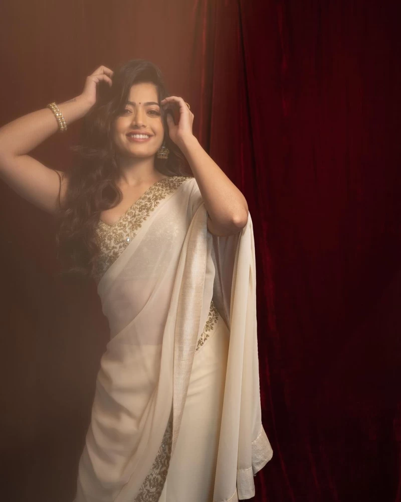 Rashmika Mandanna looks beautiful in a white saree with an embellished border.