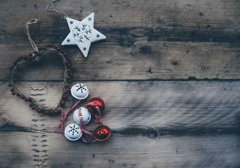 Cool Vintage Filtered Image Of Christmas Ornaments, White Star, Old Heart Decoration And Bells On A Wooden Table Surface