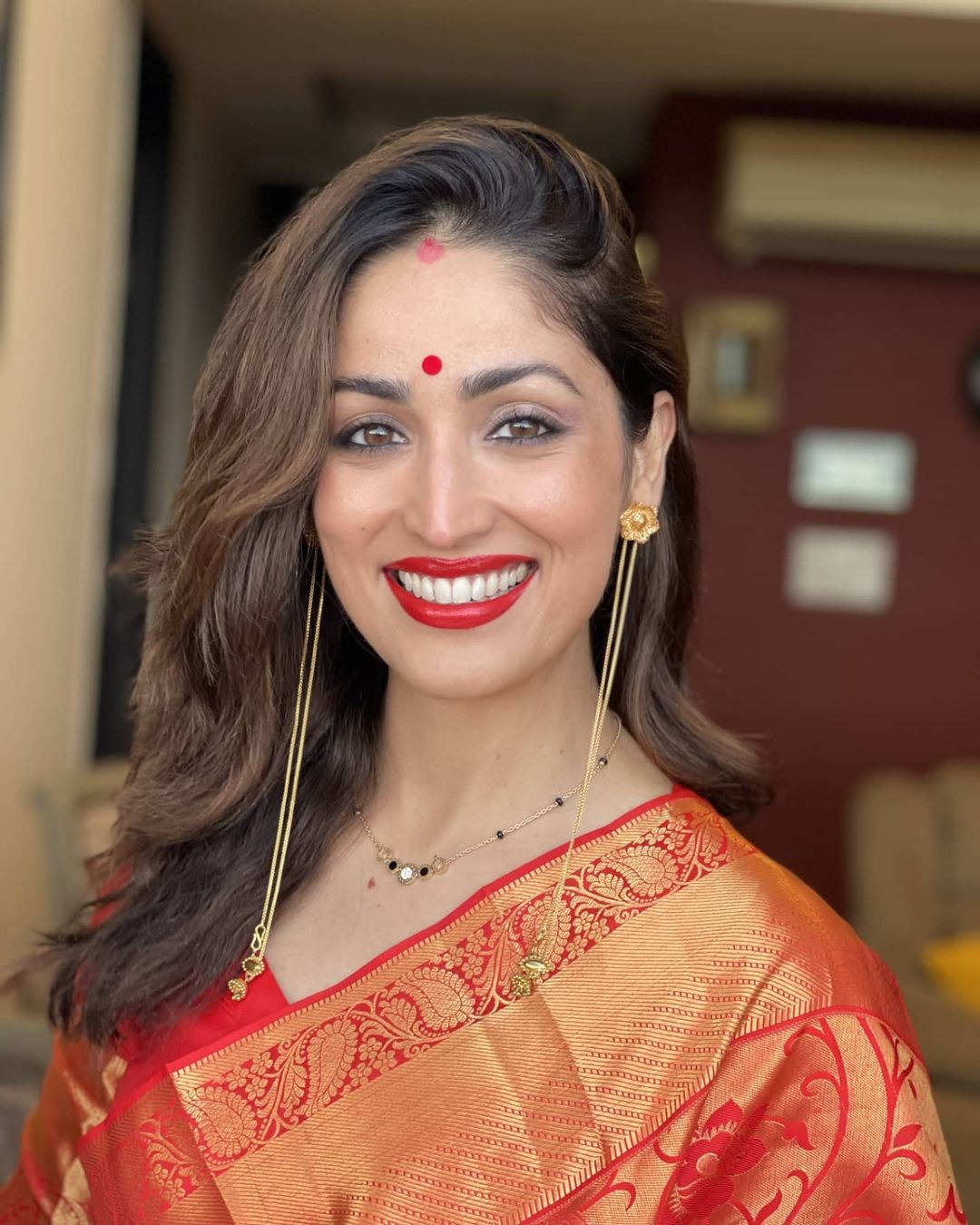 Yami Gautam looked breathtaking in a red and golden saree, complete with red lipstick and a matching bindi