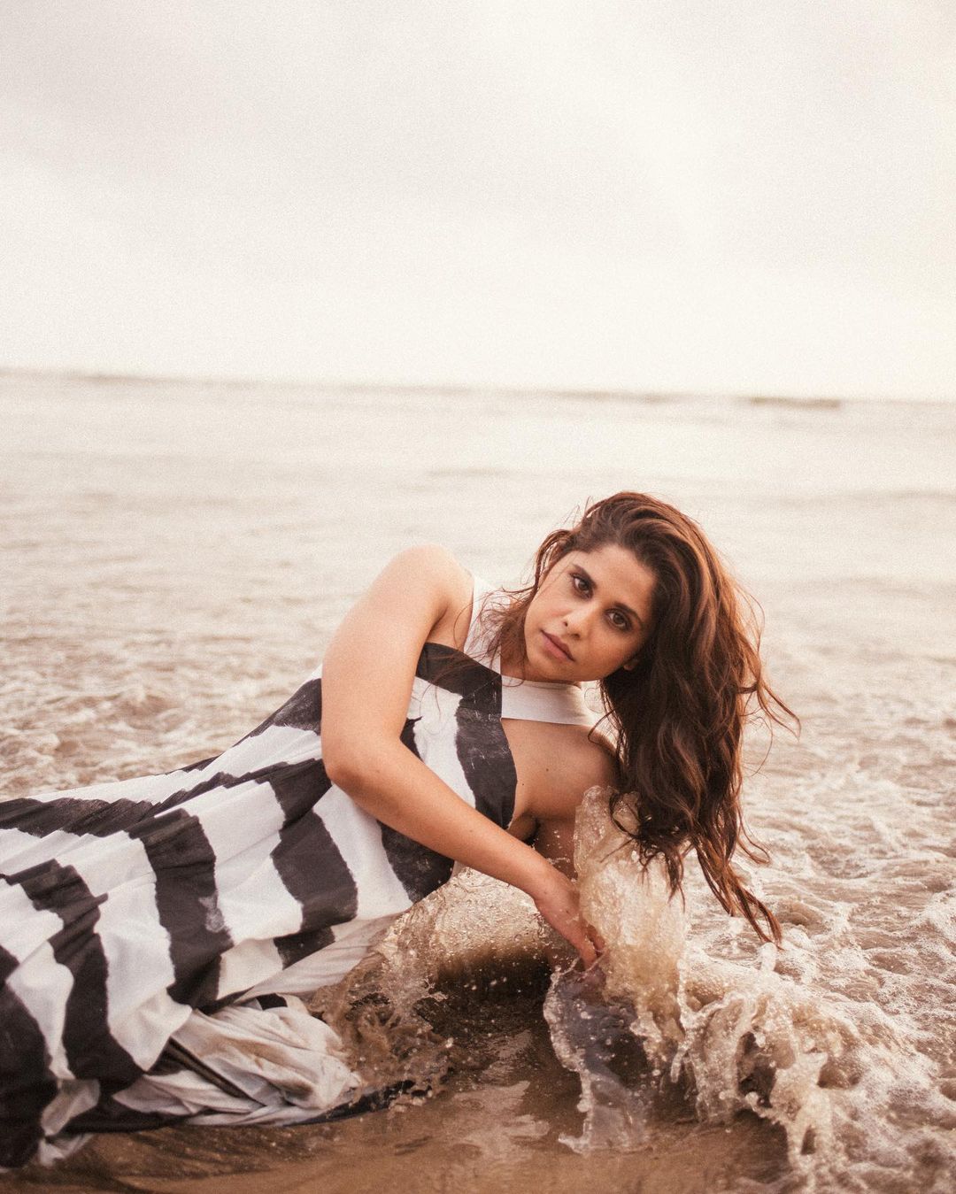 Sai Tamhankar strikes a bold pose as she dons a black and white dress at the beach