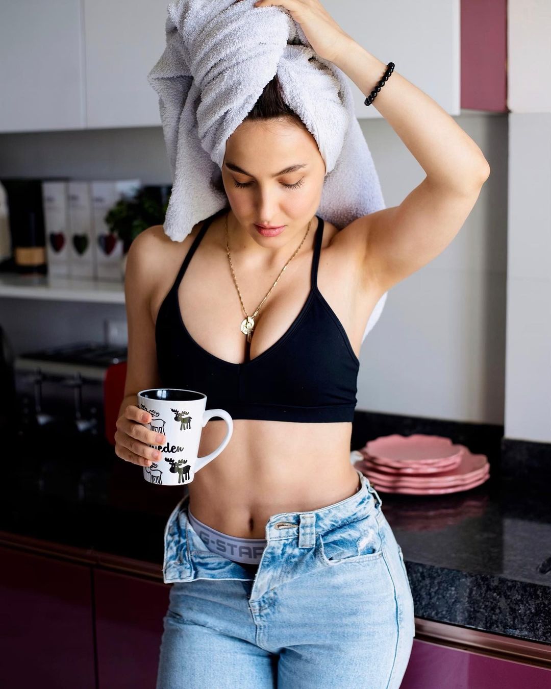 Elli AvrRam looks sexy in a black bra and blue denims, with a towel wrapped around her head