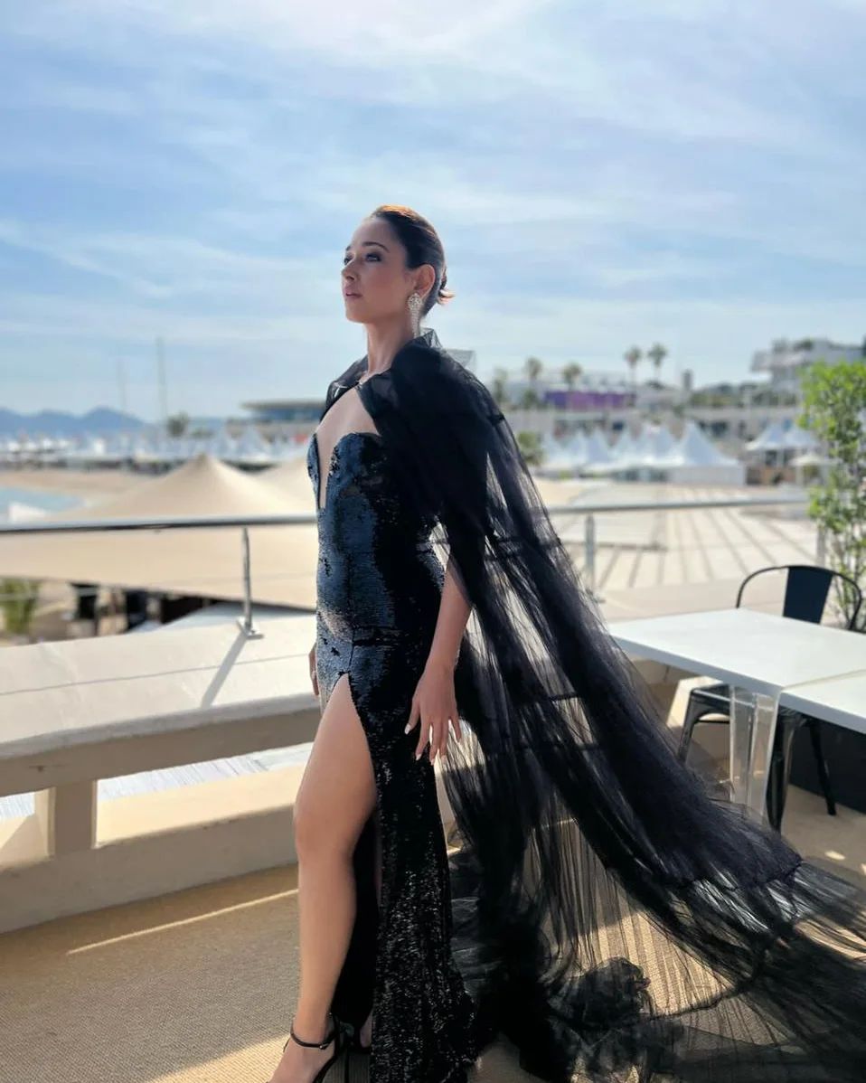 Tamannaah Bhatia looked sexy in the shimmery black slit dress with a semi-sheer cape.
