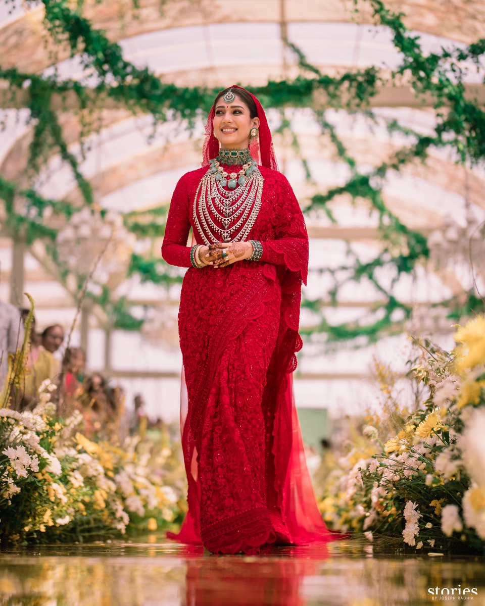 Nayanthara made a stellar entry in a deep red saree and veil. She acceesorised her look wth emerald and diamond jewellery