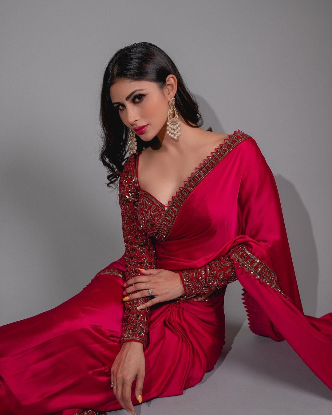 Mouni Roy pairs the plain saree with an embellished full-sleeve blouse.
