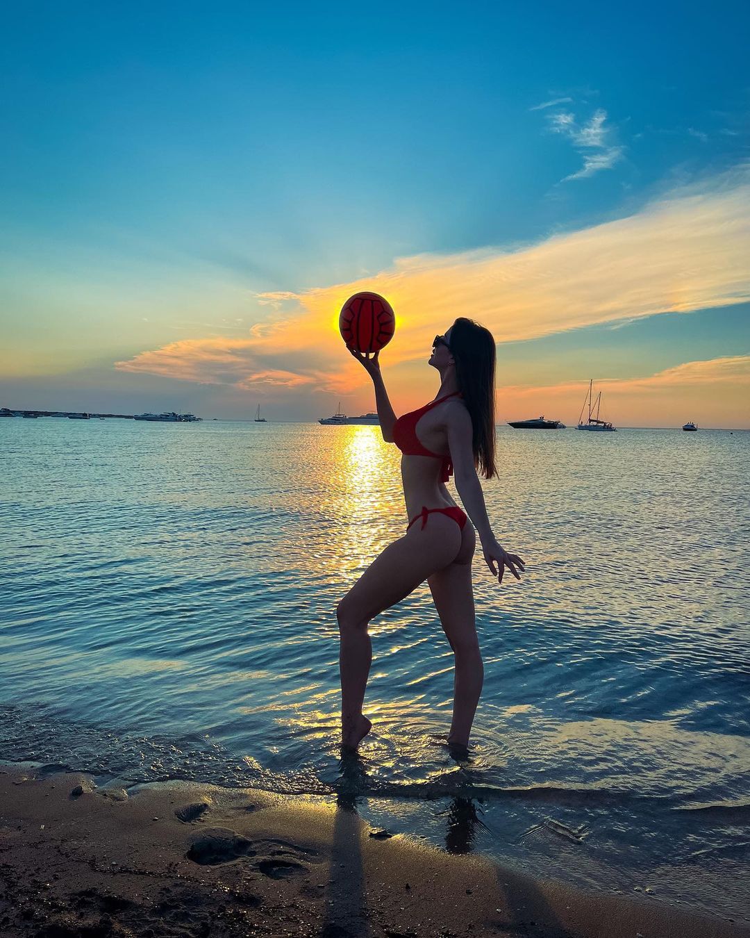 Giorgia Andriani strikes a pose with a football in hand during sunset hours