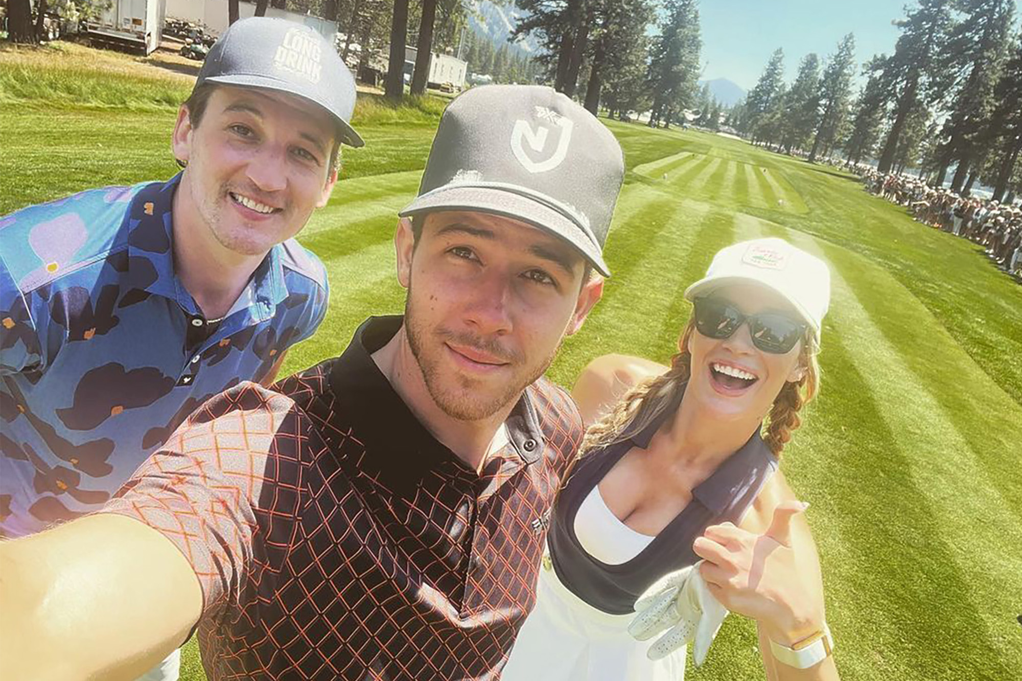 HAPPY GILMORES: It's just another day on the golf course for Paige Spiranac, but Miles Teller (left) and Nick Jonas make sure to crash the par-tee in style.