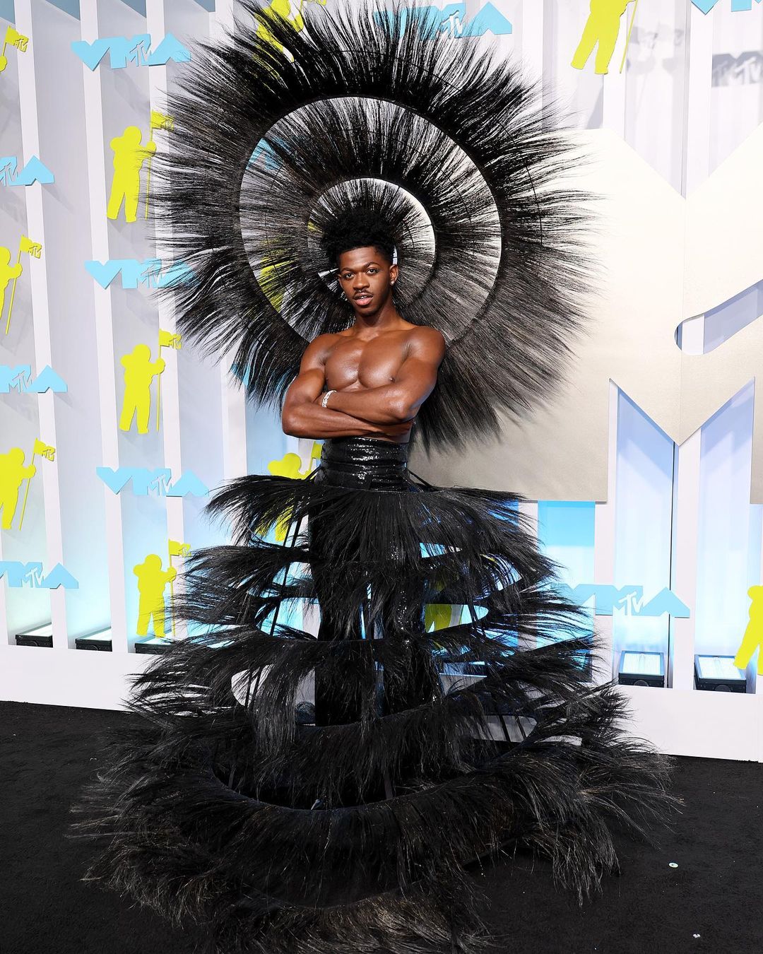 Lil Nas X served drama in a flamboyant black feather ensemble at the MTV VMAs.