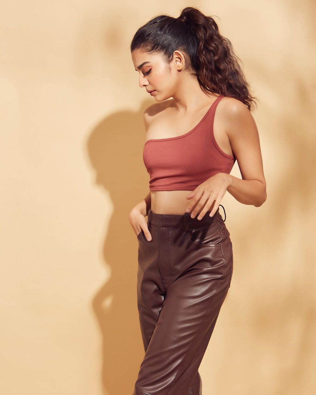 Mithila Palkar looks cool in the one-shoulder crop top and brown latex pants.