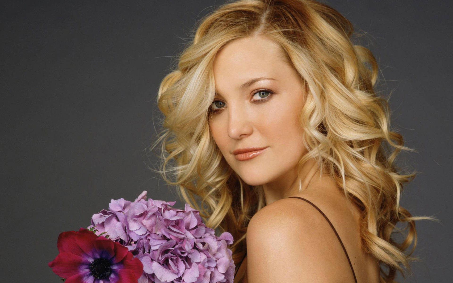 A Captivating Image Of Kate Hudson Holding Beautiful Pansy Flowers