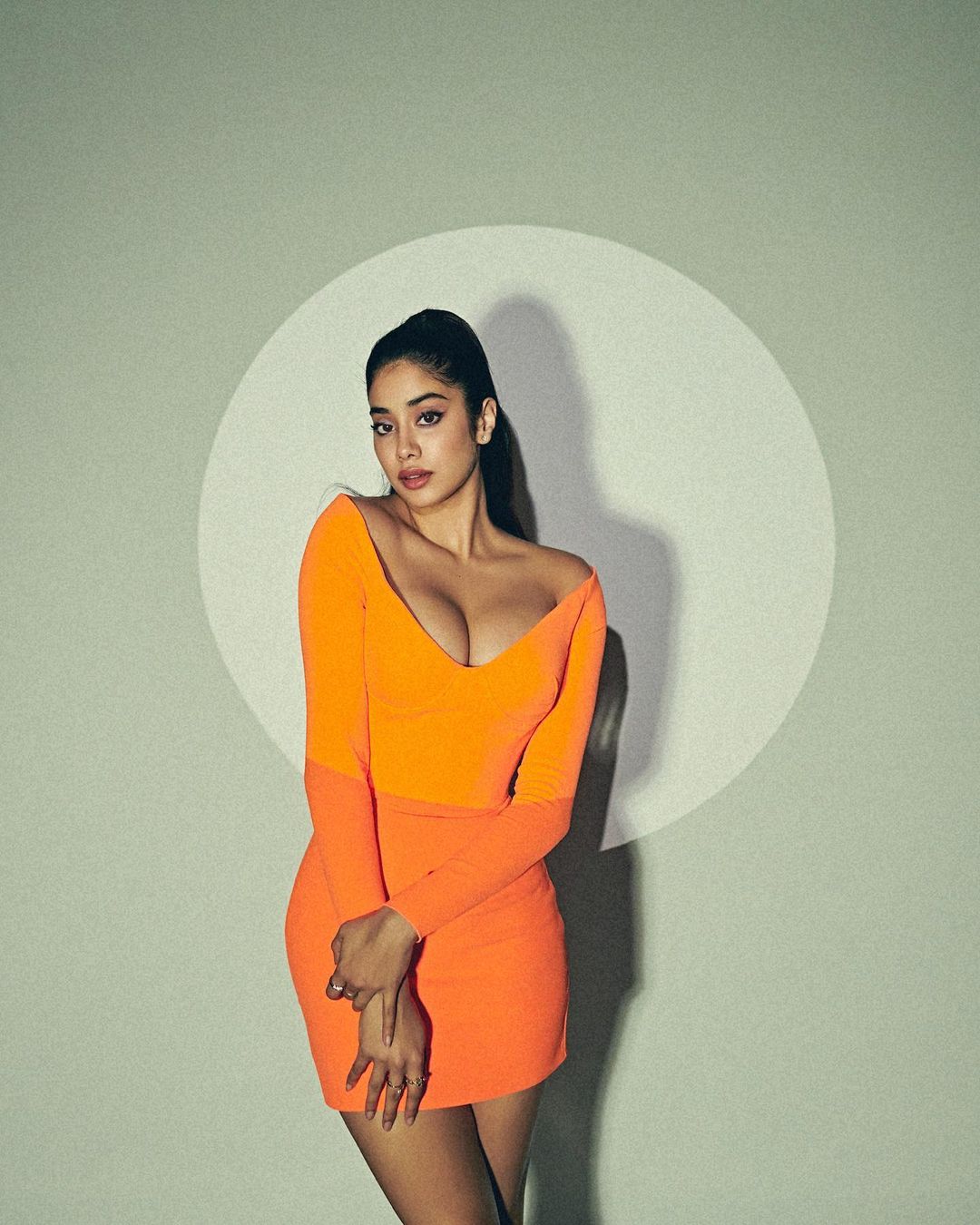 Janhvi Kapoor is raising temperature in a tangerine dress with plunging neckline.