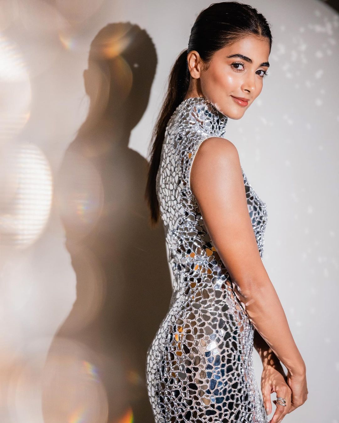 Pooja Hegde keeps her hair tied into a neat ponytail with the flamboyant outfit