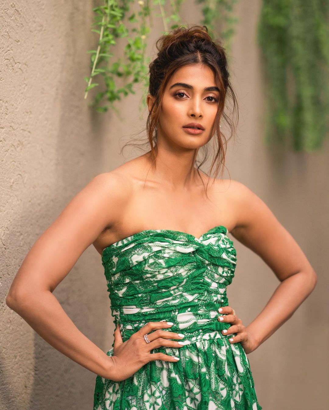 Pooja Hegde styles her hair into a messy updo to compliment the attire