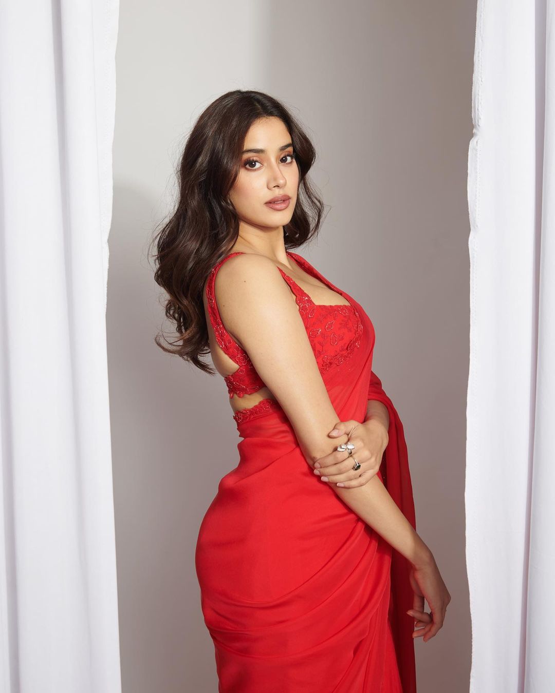 Janhvi Kapoor looks sexy in the plain red chiffon saree.