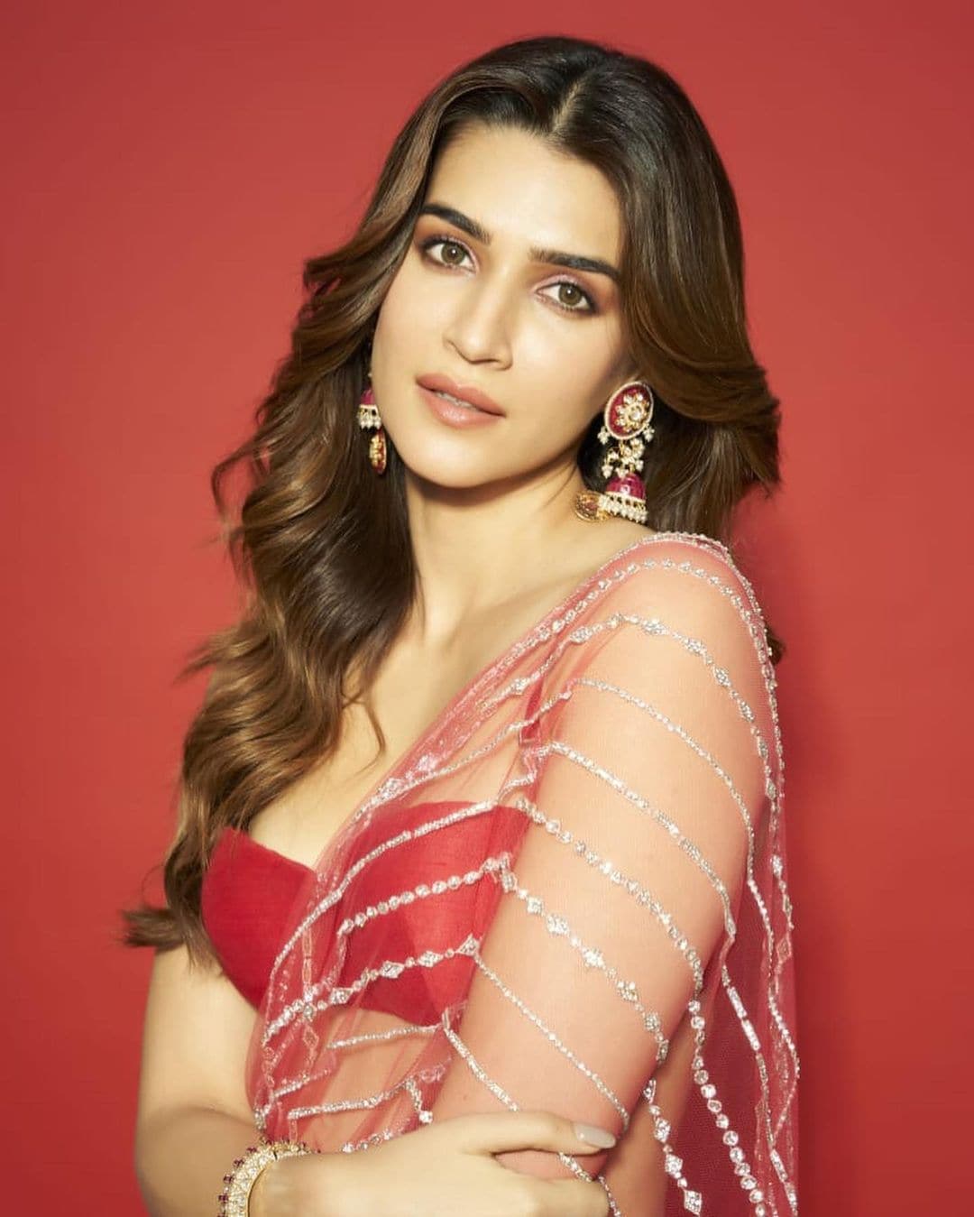 Kriti Sanon pairs the saree with a plain red blouse