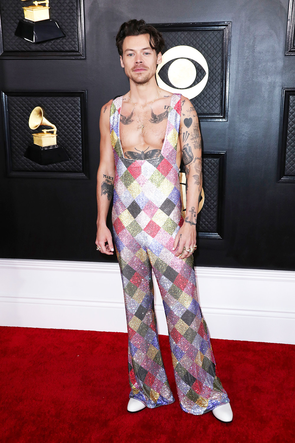 Harry Styles wore this bright colored sequin patterned Egonlab jumpsuit with no shirt underneath at the 2023 Grammy Awards