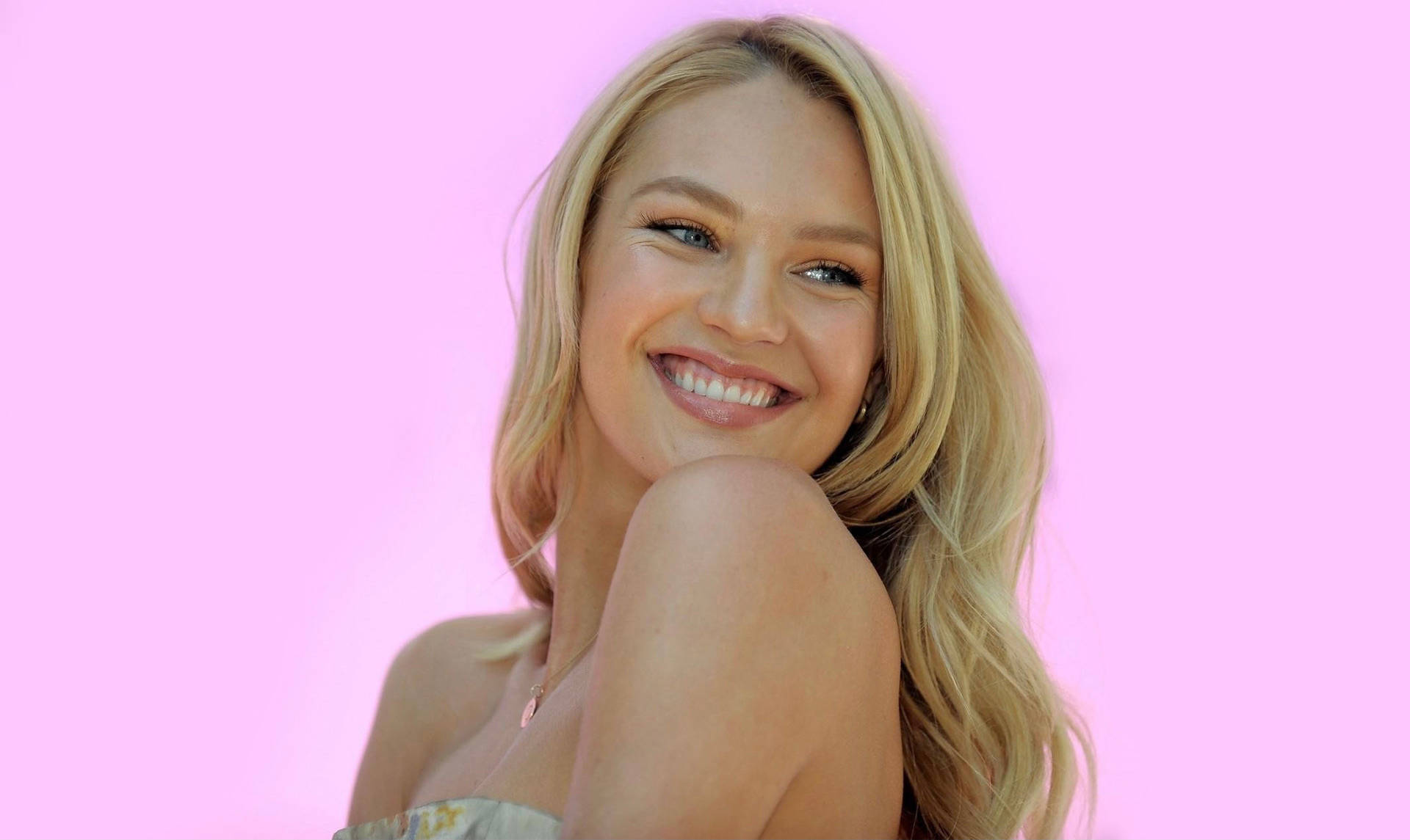 South African Supermodel Candice Swanepoel Smiling Lovingly On A Bright Pink Background
