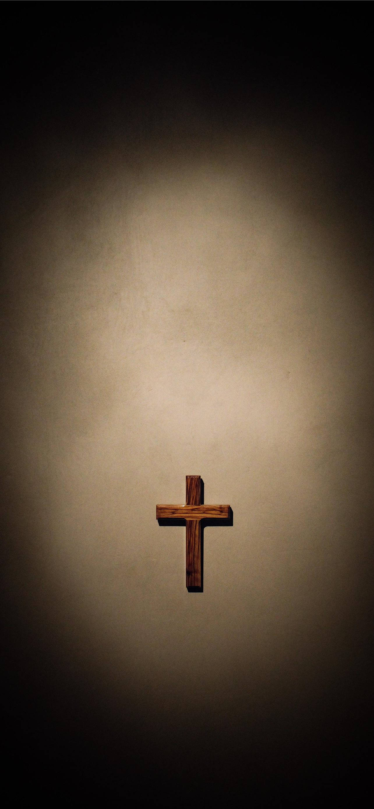 Little Wooden Cross On A Dim Lit Background In Commemoration Of The Holy Good Friday Celebration