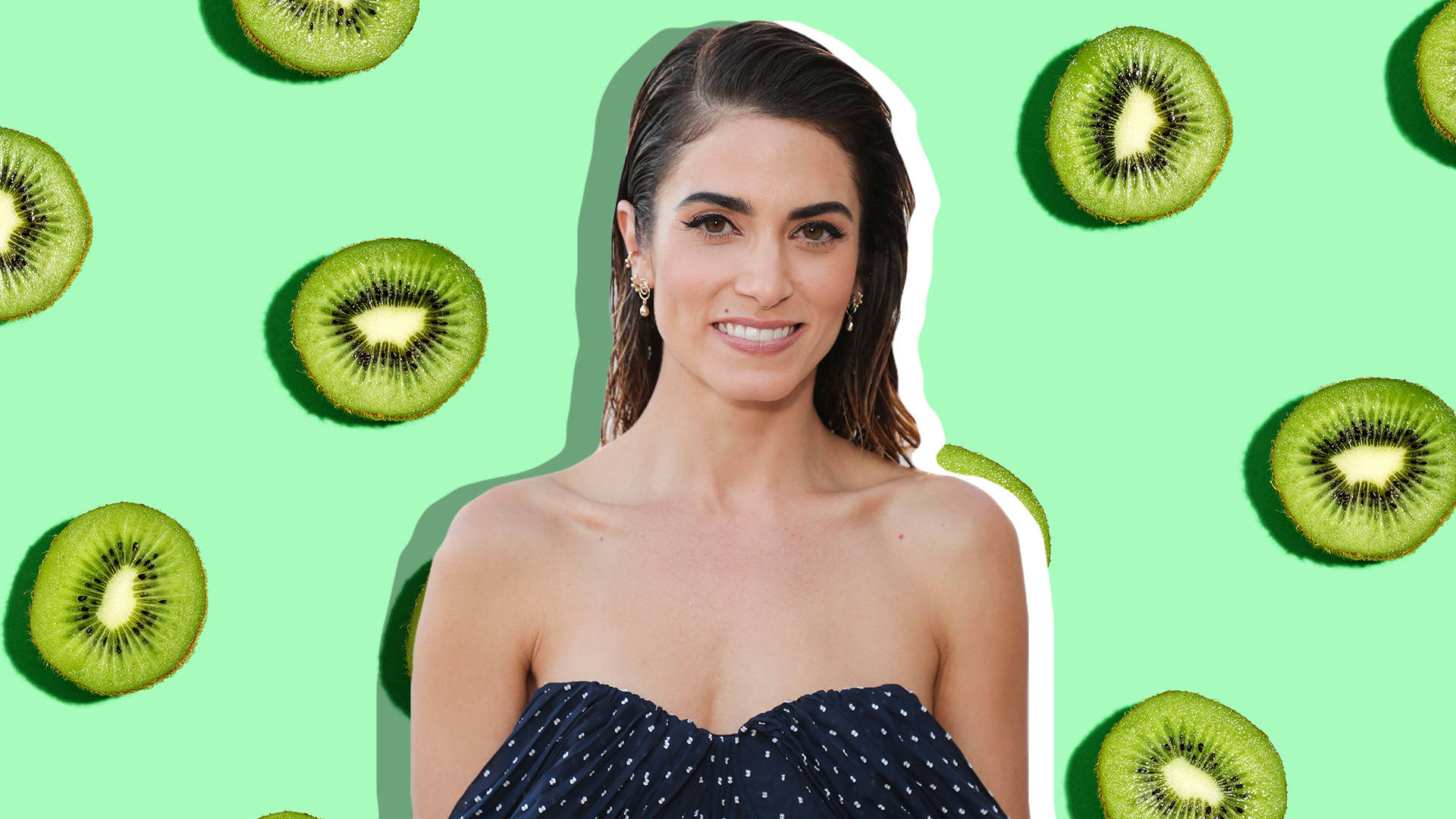 A Bewitching Poster Of A Female Star Nikki Reed Wearing A Black Dotted Dress And Smiling With A Green Kiwi Fruit Backdrop