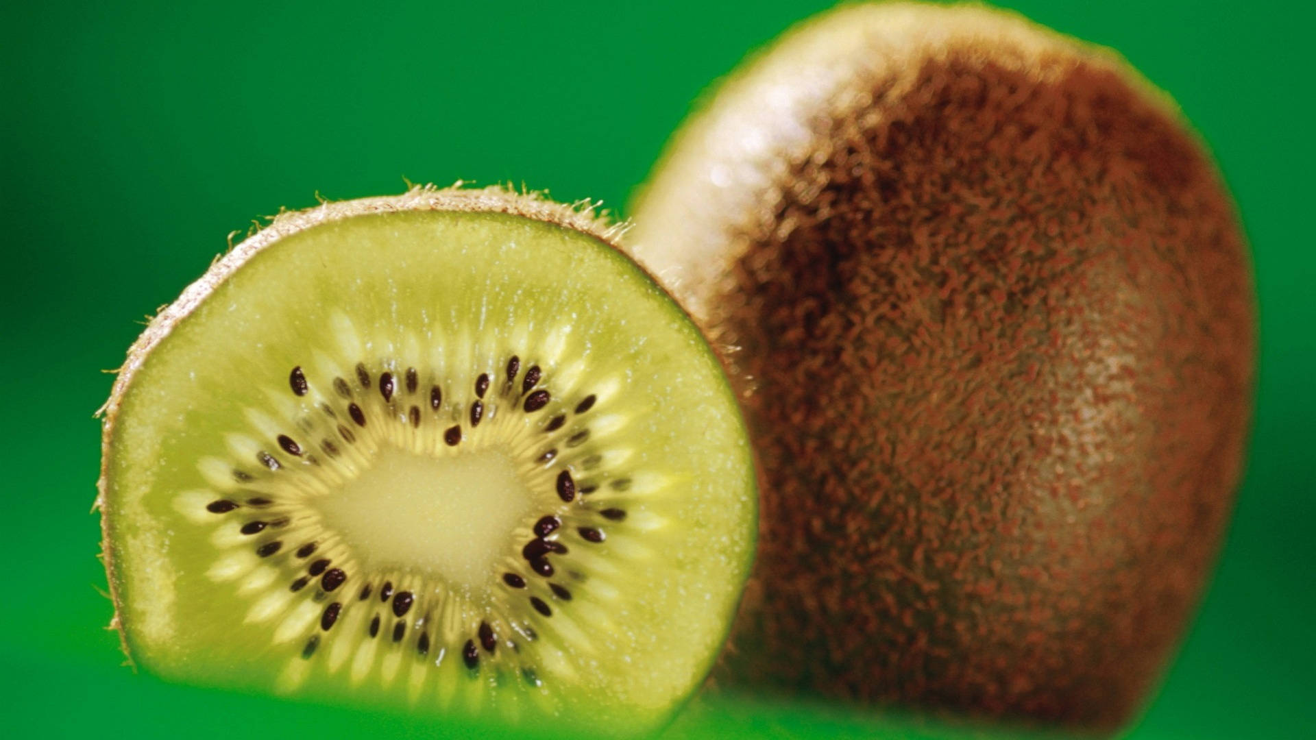 A Stark Hd Photo Of A Brown Skin Kiwi Fruit And A Kiwi Cut In Half Showing Its Whitish-green Core