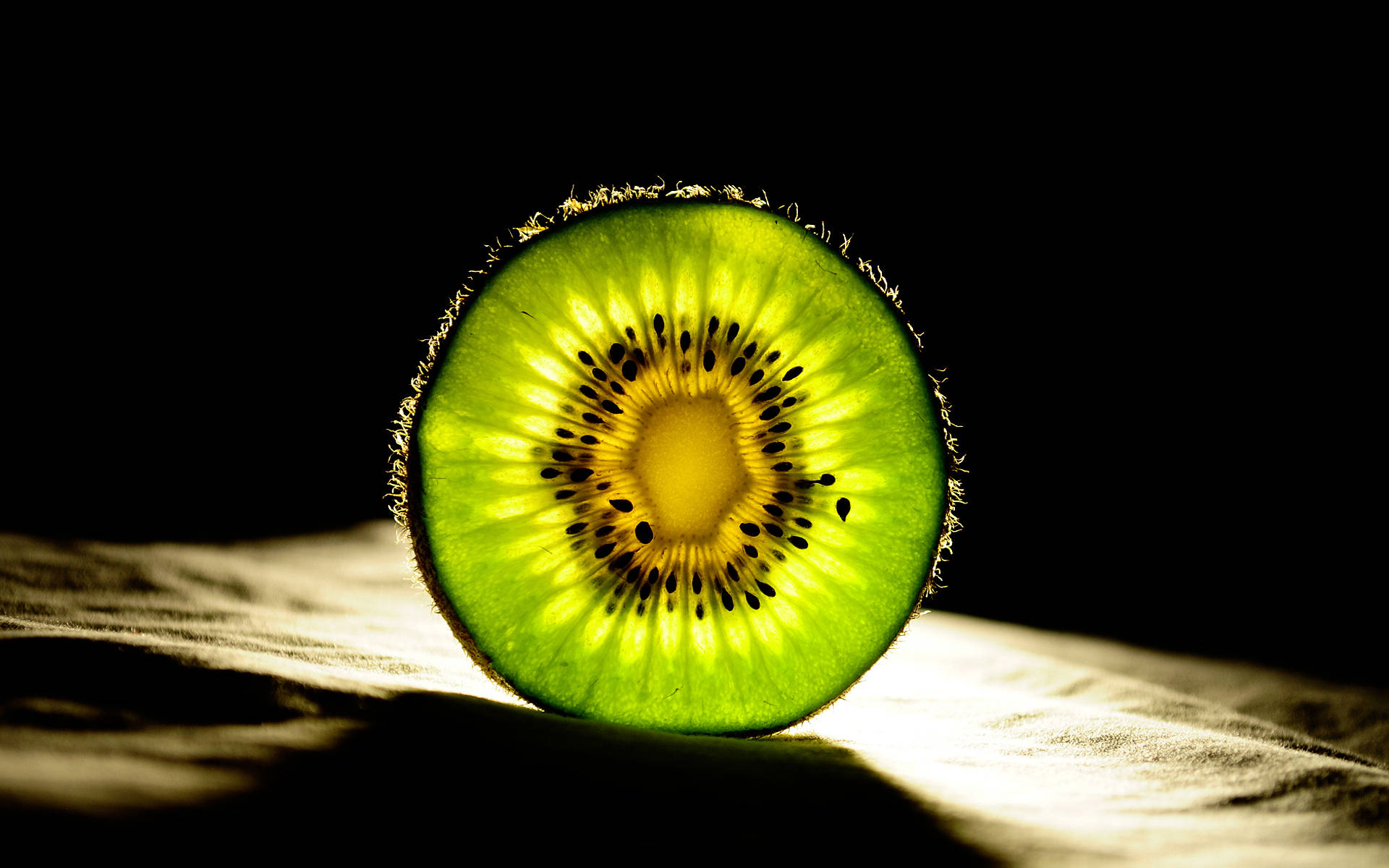 Close-up Photography Shot Of A Slice Of Kiwi With Fascinating Light Design Sourced From The Background
