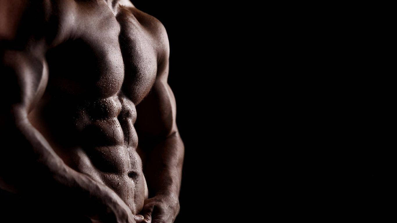 Man's Flexed Torso Muscles Against A Black Background