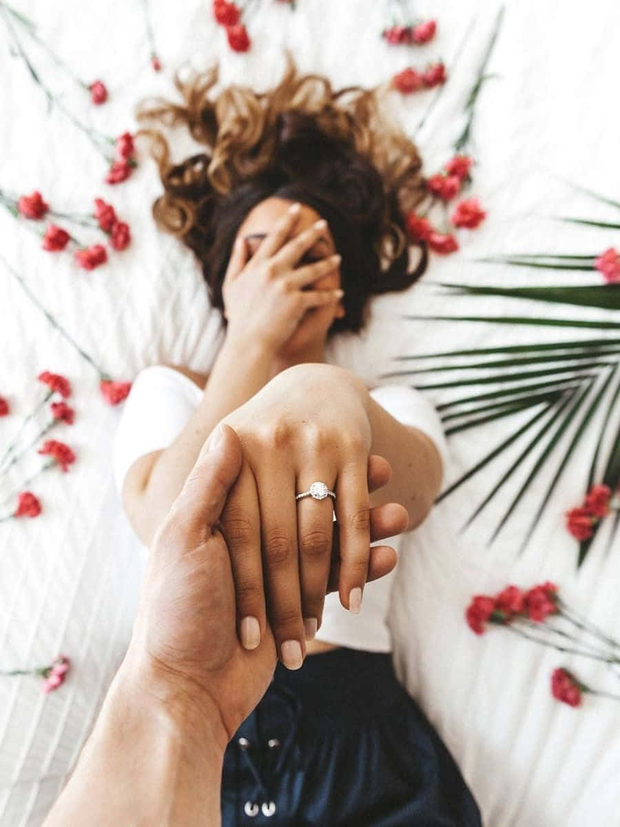 girl lying on rose petals while flaunting her engagement ring