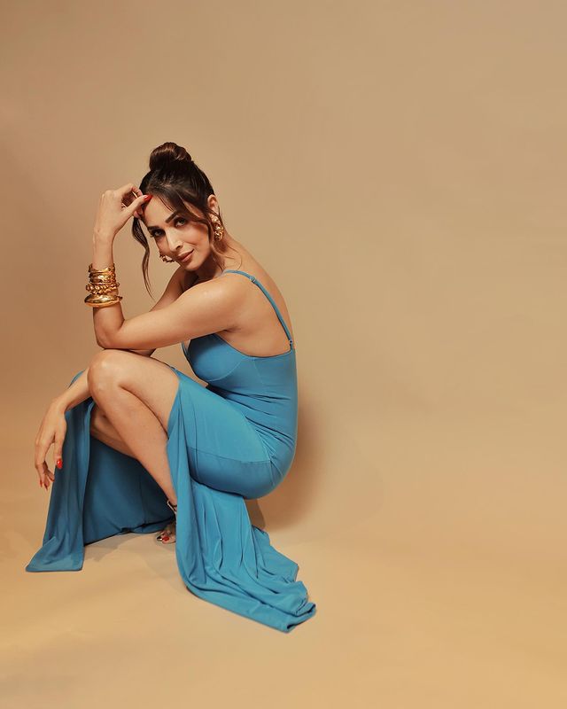 Malaika Arora wears golden accessories as a contrast to the bright blue slinky dress. Her fit frame can be definitely be owed to her regular yoga sessions and other fitness routines. The 49-year-old single mother is proof that if you prioritise your well-being, you are going to rock it out (no matter the age!).
