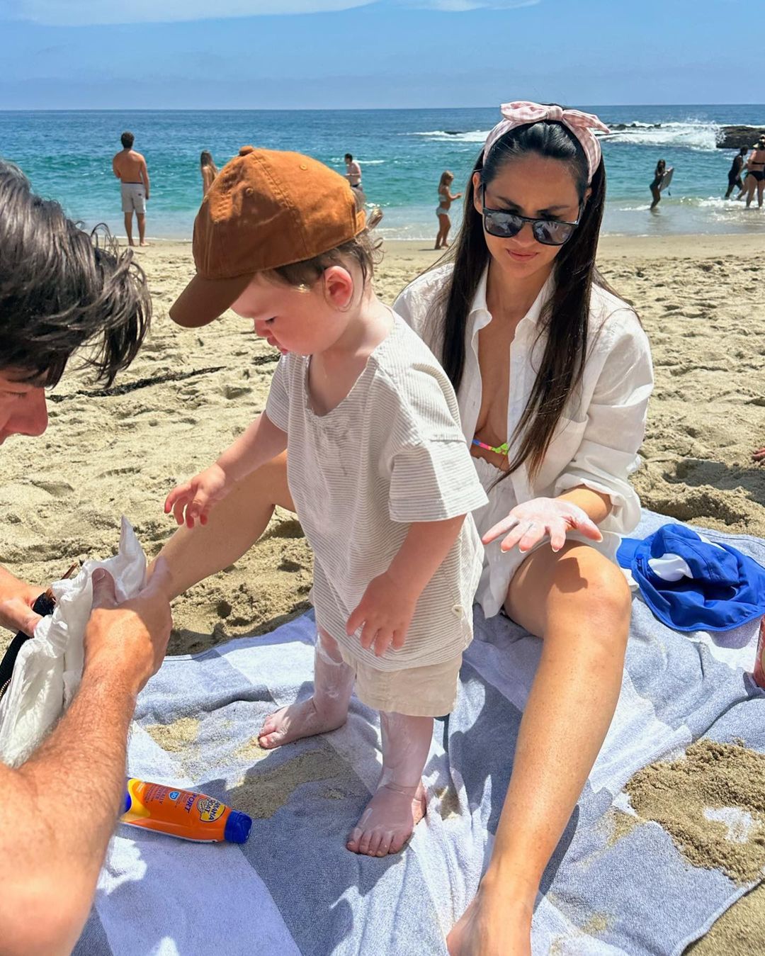 Olivia Munn and John Mulaney try their best to put sunscreen on their son, Malcolm.