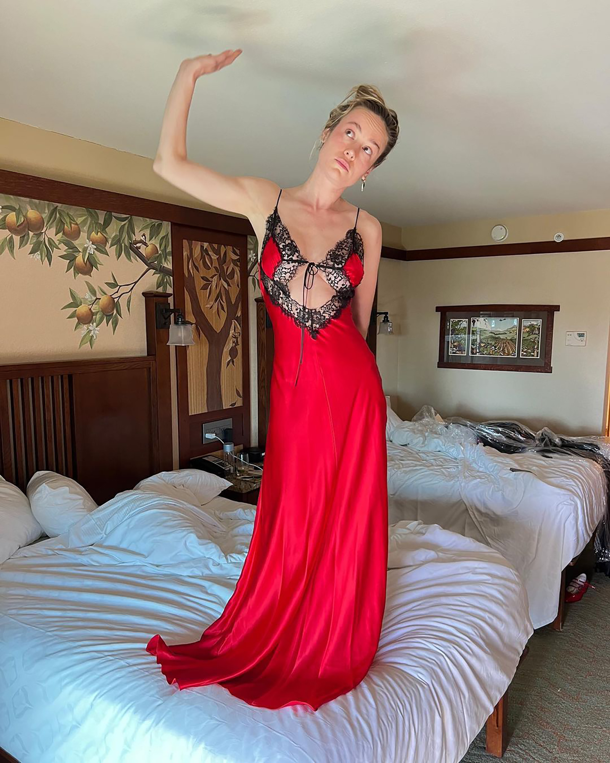 Brie Larson shared a makeup-free snap in a sultry crimson slip dress while on vacation
